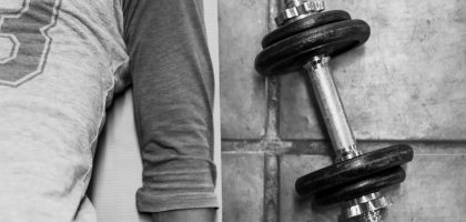 person in black pants and black socks holding dumbbell