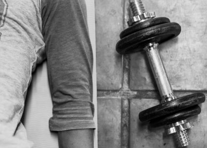 person in black pants and black socks holding dumbbell